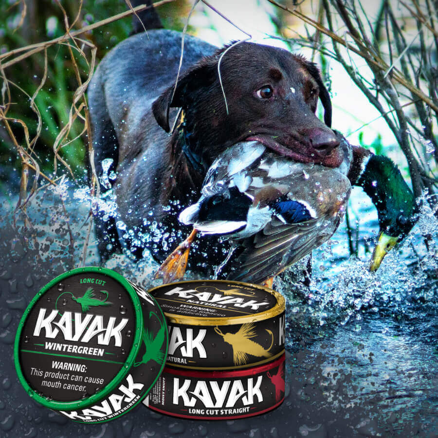 Dog with a duck in its mouth wading through water. Kayak Dip cans in the foreground.