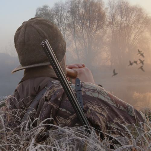 Hunter in the water using a duck call