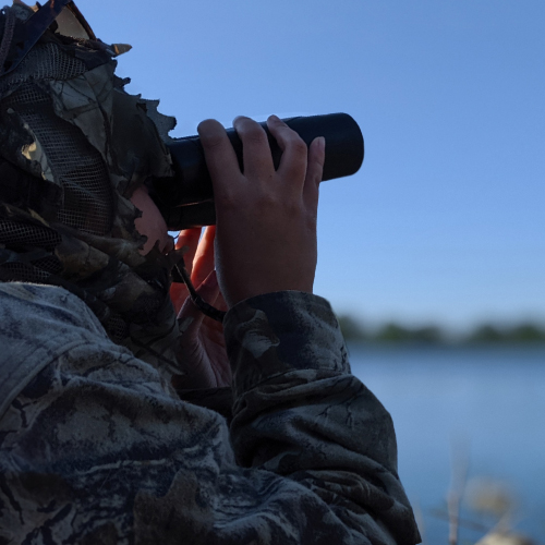 Hunter looking through binoculars