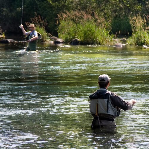 Two fishermen wading in a lake